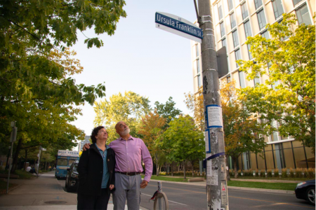 Monica Franklin and Martin Franklin, children of the late University Professor Emerita Ursula Franklin, look at the street sign bearing her name on U of T's St. George campus (photo by Johnny Guatto)
