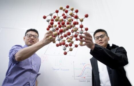 Professor Yu Zou (MSE) and Mingqiang Li (MSE PhD candidate) hold an atomic structure model of a crystal whose defects change material properties. (Photo: Adrian So)